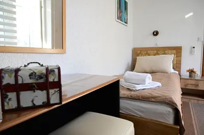 a small bedroom with a bed with a mirror at Apartman Nur in Bihać