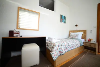 a small bedroom with a bed and a window at Apartman Nur in Bihać