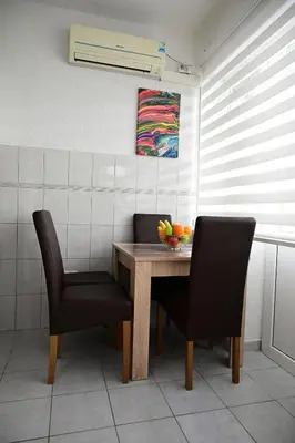 a dining room table with two chairs and a bowl of fruit at Apartman Nur in Bihać