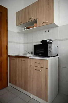 a kitchen with a microwave and a sink at Apartman Nur in Bihać