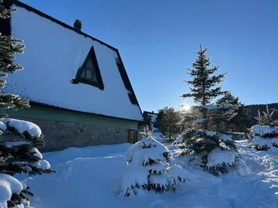 a church with snow covered trees in front of it at Vikendica Mati in Kupres