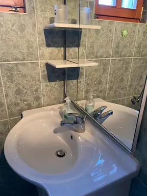 a bathroom with a white sink and a mirror at Vikendica Mati in Kupres