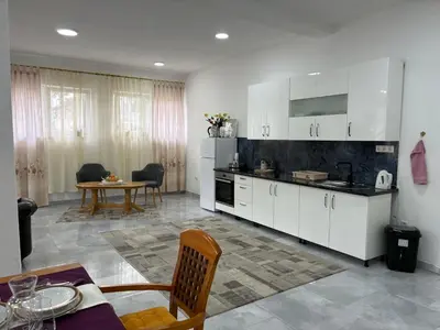 a kitchen with white cabinets and a table in a room at Apartman Jasmina in Pokoj