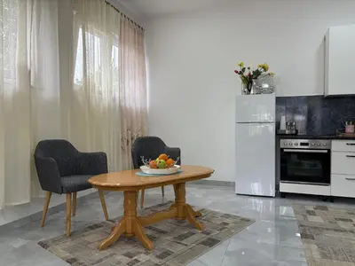 a kitchen with a wooden table and two chairs at Apartman Jasmina in Pokoj