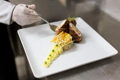 a person is eating food on a white plate at Hotel Jelena in Banja Luka