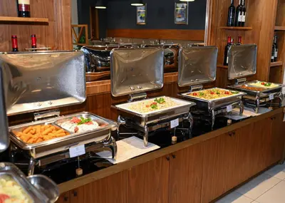 a buffet line with several trays of food at Hotel Jelena in Banja Luka