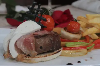 a plate of food with a sandwich and french fries at Hotel Jelena in Banja Luka