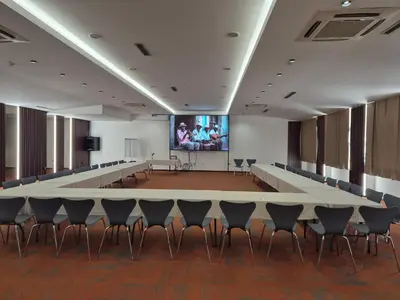 a large lecture hall with a large table and chairs at Hotel Jelena in Banja Luka