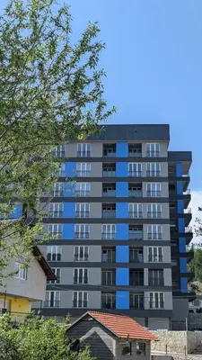 a tall apartment building with blue windows at Apartment SKY in Travnik