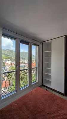 a bedroom with windows with a view of a city at Apartment SKY in Travnik