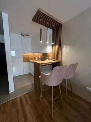 a kitchen with a table and two purple chairs at Elita Apartmani in Ivišovo Greblje
