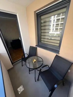 a room with two chairs and a table and a window at Elita Apartmani in Ivišovo Greblje
