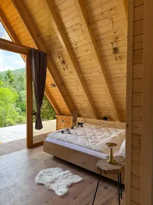 a bedroom with a large bed in a wooden ceiling at Cottage Lana 2 in Jajce