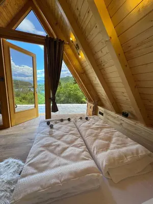 a bed in a room with a large window at Cottage Lana 2 in Jajce