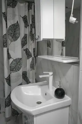 a bathroom with a sink and a shower curtain at Apartman Amna in Jajce