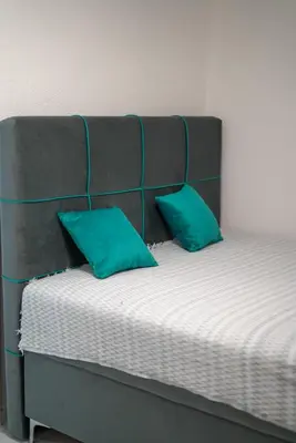 a bed with two mint green pillows on it at Apartman Amna in Jajce