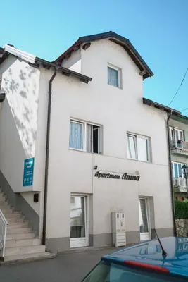 a white building with a sign on it at Apartman Amna in Jajce