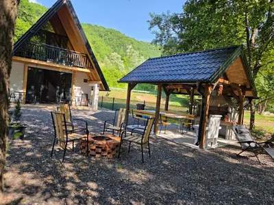 a pavilion with chairs and a picnic table and a building at Villa Tea in Šipovo