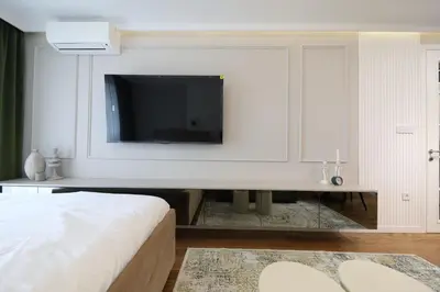 a bedroom with a flat screen tv on a white wall at GRAND LUX view in Banja Luka