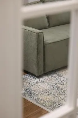 a couch sitting in a living room with a rug at GRAND LUX view in Banja Luka