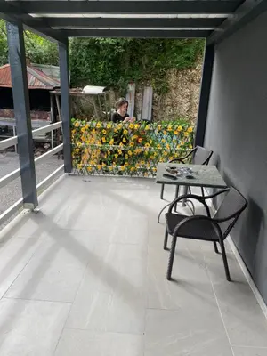 a table and a chair on a balcony with flowers at Marshal 2