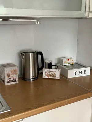 a counter top with a coffee pot and boxes on it at Apartman Pannonica Centar in Tuzla