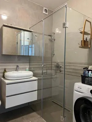 a bathroom with a sink and a glass shower at Apartman Pannonica Centar in Tuzla