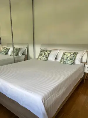 a bedroom with two beds with white sheets and pillows at Apartman Pannonica Centar in Tuzla
