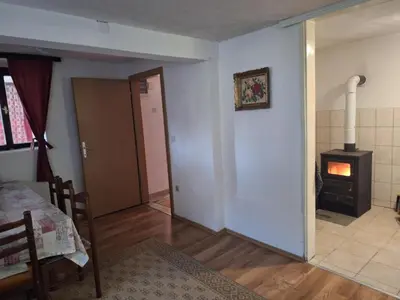 a living room with a room with a stove in it at Kuća Knežević in Mlječanica