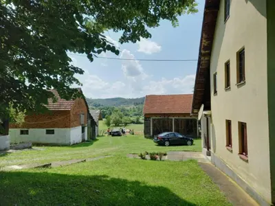 a view of a barn and a car parked in a yard at Kuća Knežević in Mlječanica