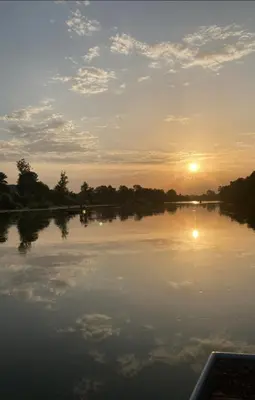 a view of a lake with the sun setting at Apartmani Una Lux2 in Spilja