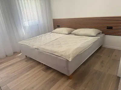 a large bed in a bedroom with a wooden floor at San Travnik in Travnik