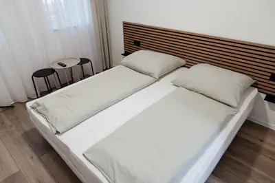 a bed with white sheets and pillows in a bedroom at San Travnik in Travnik