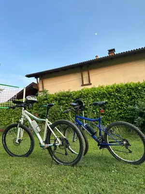 two bikes parked in the grass in front of a house at Apartman Green River Banja Luka in Bijeli Potok