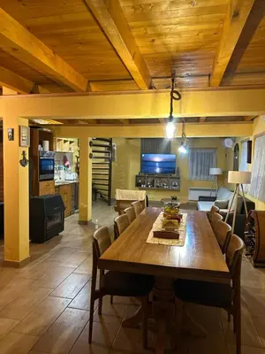 a dining room with a wooden table and chairs at Apartman Green River Banja Luka in Bijeli Potok