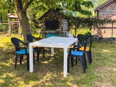 a table and chairs in front of a stone oven at Guest House Seka in Bihać