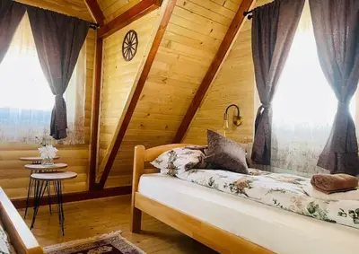 a bedroom with a bed in a wooden cabin at Planinska kuća Jelka in Mlinište