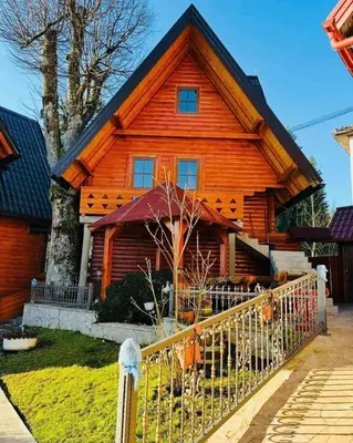 a wooden house with a fence in front of it at Planinska kuća Jelka in Mlinište
