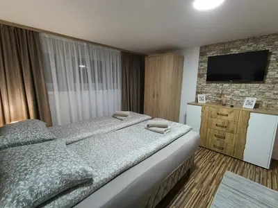 a bedroom with a bed and a television on a wall at Apartman 4A in Bihać