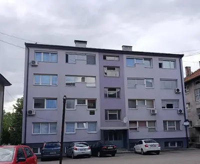 a large building with cars parked in front of it at Apartman 4A in Bihać