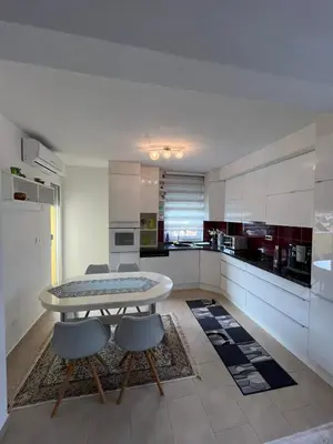 a kitchen with a table and chairs in a room at Apartman Murtić in Bihać