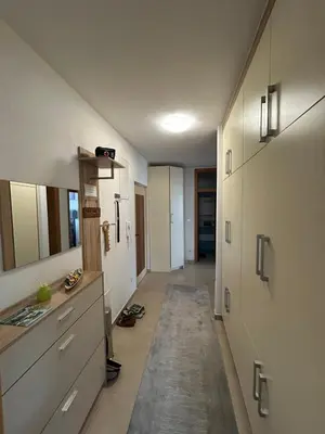 a room with a hallway with white cabinets and a rug at Apartman Murtić in Bihać