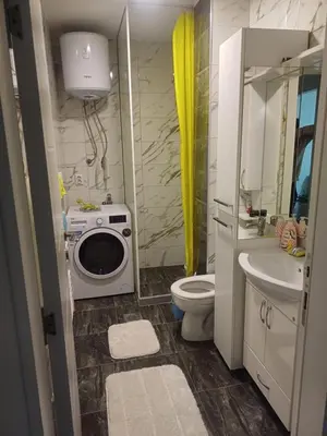 a bathroom with a toilet sink and a washing machine at Stan na dan Srebrenik in Srebrenik