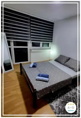 a bed in a room with a large window at Apartman A-D in Bihać