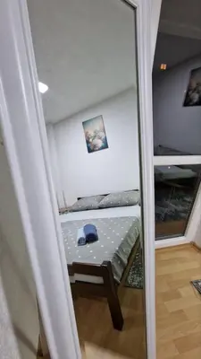 a mirror reflection of a bed in a room at Apartman A-D in Bihać