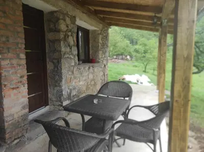 a patio with a table and chairs on a porch at Bad and Breakfast Majestik in Gornji Ribnik