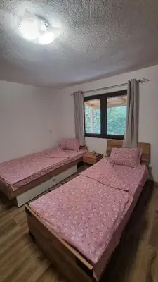 two beds in a room with pink sheets at Bad and Breakfast Majestik in Gornji Ribnik