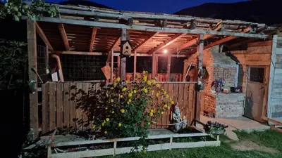a wooden pergola in a backyard at night at Bad and Breakfast Majestik in Gornji Ribnik