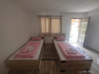 a bedroom with two beds with pink sheets and a window at Bad and Breakfast Majestik in Gornji Ribnik