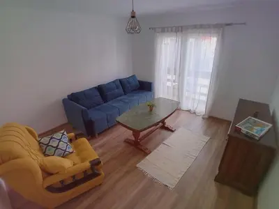 a living room with a blue couch and a table at RelaxApartment in Tuzla